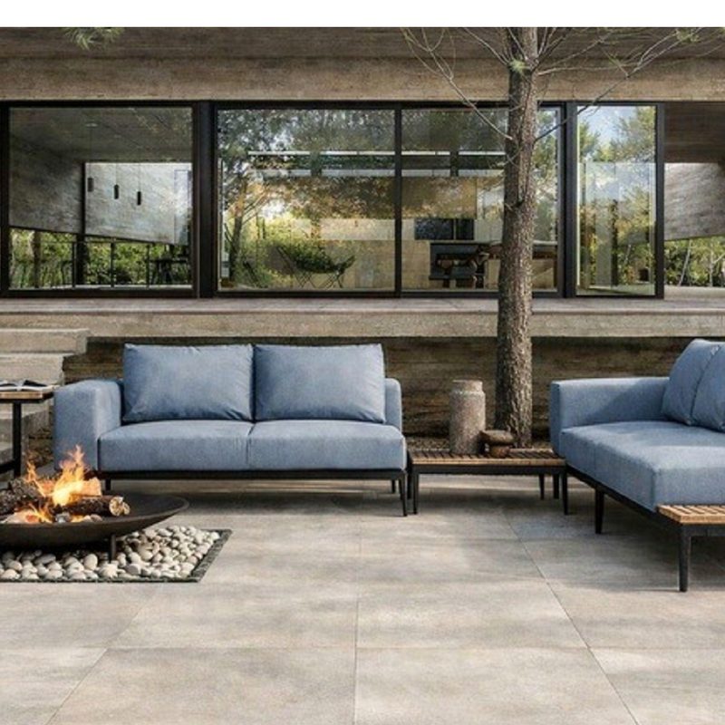 Concrete-look porcelain paver patio with fire bowl and lounge seating